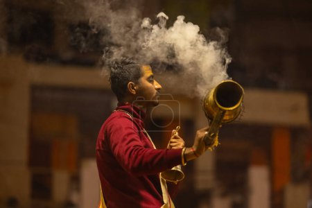 Téléchargez les photos : Varanasi, Uttar Pradesh, Inde - 18 janvier 2024 : Ganga aarti, Portrait d'un jeune prêtre effectuant des ganges de rivière sainte aarti du soir au ghat de dashashwamedh en costume traditionnel avec des rituels hindous. - en image libre de droit