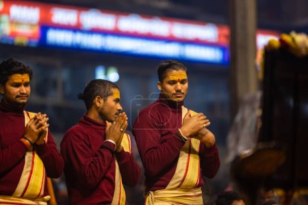 Foto de Varanasi, Uttar Pradesh, India - 18 de enero de 2024: Ganga aarti, Grupo de jóvenes sacerdotes varones que realizan pandillas del río santo aarti vespertino en dashashwamedh ghat con vestimenta tradicional con rituales hindúes. - Imagen libre de derechos