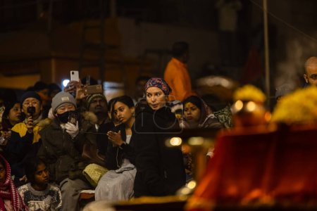 Foto de Varanasi, Uttar Pradesh, India - 18 de enero de 2024: Ganga aarti, Grupo de devotos que participan en el ganga aarti vespertino en dashashwamedh ghat en varanasi. - Imagen libre de derechos