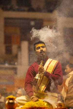 Téléchargez les photos : Varanasi, Uttar Pradesh, Inde - 18 janvier 2024 : Ganga aarti, Portrait d'un jeune prêtre effectuant des ganges de rivière sainte aarti du soir au ghat de dashashwamedh en costume traditionnel avec des rituels hindous. - en image libre de droit