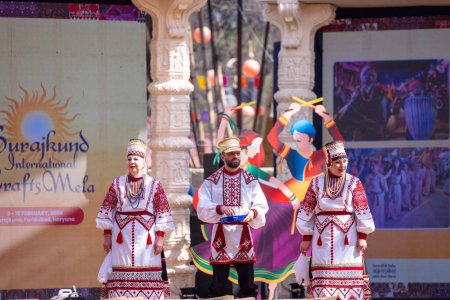 Photo for Faridabad, Haryana, India - February 17 2024: Group of foreign delegates performing their cultural dance and music on stage in traditional clothes at surajkund crafts fair. - Royalty Free Image