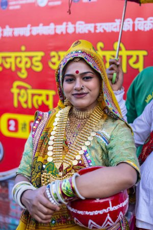 Foto de Faridabad, Haryana, India - February 17 2024: Portrait of an female artist from gujrat state in ethnic traditional dress participating in surajkund crafts fair to perform their cultural folk dance. - Imagen libre de derechos