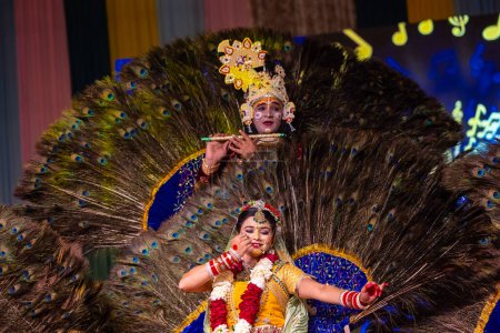 Foto de Ghaziabad, Uttar Pradesh, India - 17 de marzo de 2024: Retrato de jóvenes artistas masculinos y femeninos jugando phoolo ki holi como lord krishna y diosa radha durante el festival holi con ropa étnica colorida. - Imagen libre de derechos