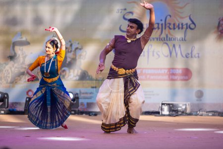 Photo for Faridabad, Haryana, India - February 17 2024: Group of male and female south indian artists performing classical dance kuchipudi on stage during surajkund crafts fair in ethnic costumes. - Royalty Free Image