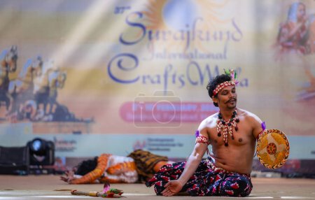 Téléchargez les photos : Faridabad, Haryana, Inde - 17 février 2024 : Portrait d'artistes du sud de l'Inde exécutant des kuchipudi de danse classique comme chasseur et tigre sur scène en vêtements ethniques lors de la foire artisanale surajkund. - en image libre de droit