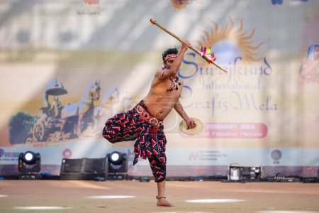 Téléchargez les photos : Faridabad, Haryana, Inde - 17 février 2024 : Portrait d'un artiste du sud de l'Inde exécutant des kuchipudi de danse classique en tant que chasseur sur scène en vêtements ethniques lors d'une foire artisanale surajkund. - en image libre de droit