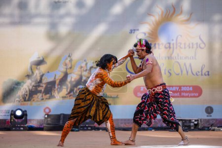 Foto de Faridabad, Haryana, India - 17 de febrero de 2024: Retrato de artistas masculinos del sur de la India realizando danza clásica kuchipudi como cazador y tigre en el escenario con ropa étnica durante la feria de artesanía surajkund. - Imagen libre de derechos