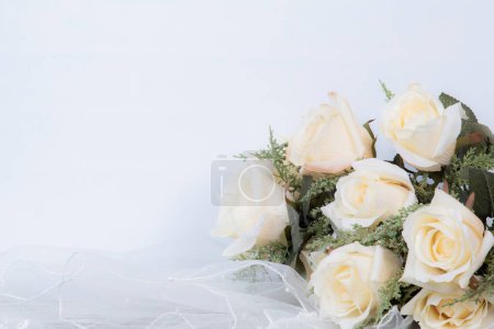 Téléchargez les photos : Rayon plat de l'anneau de mariage, chapeau de mariée, couronne, roses et bijoux sur fond blanc avec espace de copie / fond de mariage ou concept d'anniversaire - en image libre de droit