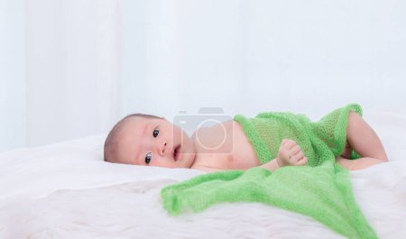 Asian newborn open her eyes looking for mom or food, infant curiosity look around the bedroom