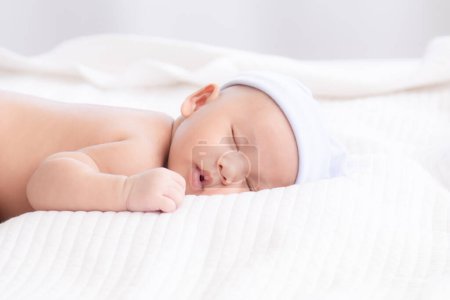 Photo for Adorable Asian newborn baby deeply sleeping smile Easter costume hat, tiny infant boy soft skin healthy sleep dream on white blanket on bed beautiful sun light, newborn baby health care concept - Royalty Free Image