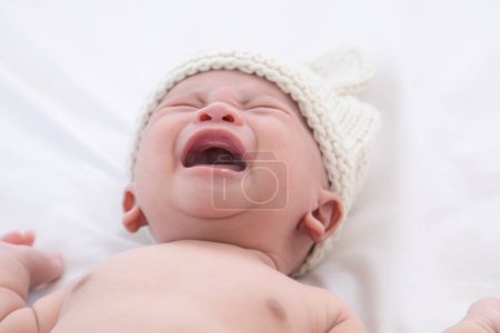 Neugeborenes Baby weint krank Fieber, Grippe-Check in Klinik, asiatisches Kind Säugling 0-1 Monat wählerisch schreit unglücklich wütend, hungrig im Bett zu Hause, Kinderzimmer Junge raue harte Textil unbequeme Decke