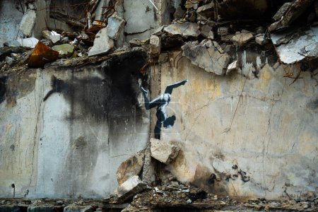 Photo for Borodyanka, Kyiv region 11.12.2022 The work of the mural of the British street artist Banksy on the wall of a destroyed house after the invasion of Russia in Ukraine. Gymnast girl stands on her hands - Royalty Free Image