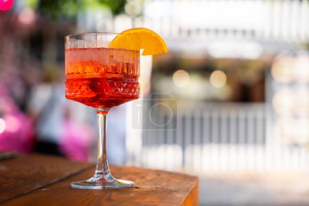 Téléchargez les photos : Deux cocktails apéritifs pétillants avec garniture orange, sur une surface de bar en bois, avec un fond bokeh lumières - en image libre de droit