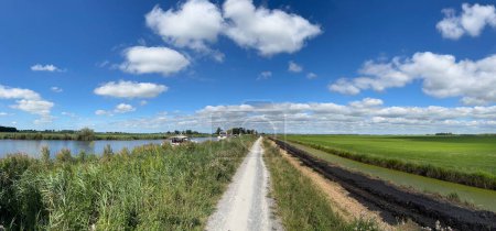 Téléchargez les photos : Panorama depuis un chemin de gravier à côté d'un canal autour de Broek en Frise aux Pays-Bas - en image libre de droit
