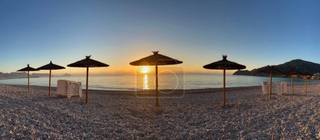 Photo for Panorama from parasols with sunrise on the beach in Albir Spain - Royalty Free Image
