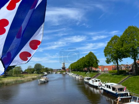 Kanal rund um die Stadt Dokkum mit friesischer Flagge, Friesland Niederlande