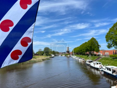 Canal autour de la ville Dokkum avec un drapeau frisien, Frise Pays-Bas