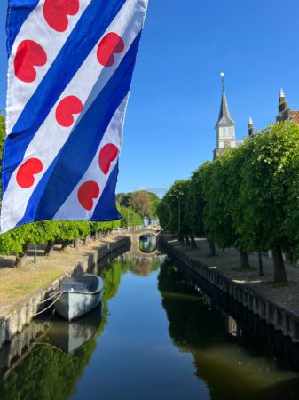 Frisian flag at the canal in Sloten, Friesland the Netherlands