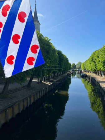 Frisian flag at the canal in Sloten, Friesland the Netherlands