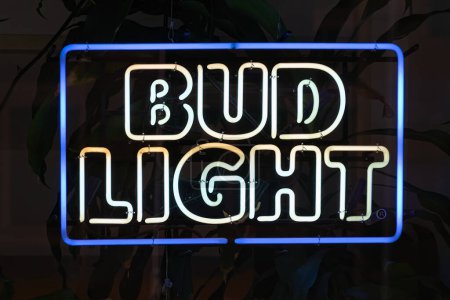 Foto de Nueva York, NY - 17 de septiembre de 2023: Bud Light cartel de neón de la marca de cerveza en la ventana del bar por la noche - Imagen libre de derechos