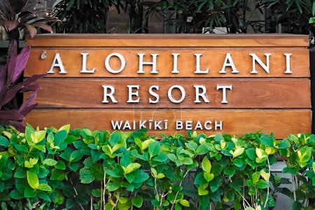 Téléchargez les photos : Honolulu, Hawaï - 10 décembre 2023 : 'Alohilani Resort Waikiki Beach enseigne de luxe en bois de l'hôtel en bord de mer sur Kalakaua Ave sur l'île d'Oahu. - en image libre de droit