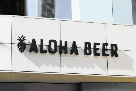 Foto de Honolulu, HI - December 9, 2023: Local Hawaiian microbrewery and beer garden Aloha Beer signage with name and logo on bar location in sunny Waikiki - Imagen libre de derechos