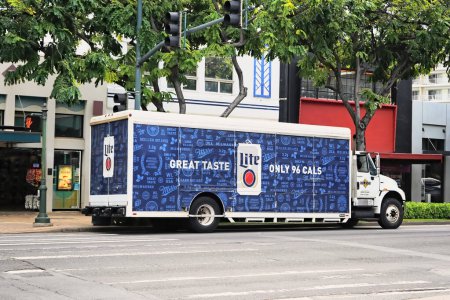 Foto de Honolulu, HI - 12 de enero de 2024: Miller Lite brand beer, Molson Coors owned Miller Brewing Company delivery truck on city street stocking local store. - Imagen libre de derechos