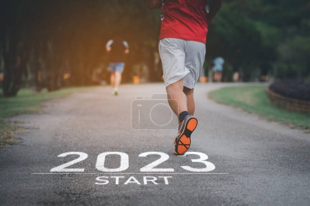 Photo for Sport man running at park garden. Start into the new year 2023. Start up of runner woman running on nature race track go to Goal of Success. People running as part of Number 2023. Sport health care. - Royalty Free Image