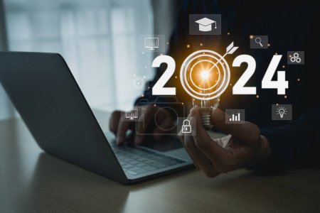 2024 new year trends technology. Businessman holding bulb virtual display screen of graduation hat, education icons. E-learning Education webinar online courses . Education idea learning online.-stock-photo