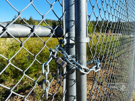 Photo for A locked padlock chainlink fence lock secure chain steel wires security yard gate - Royalty Free Image
