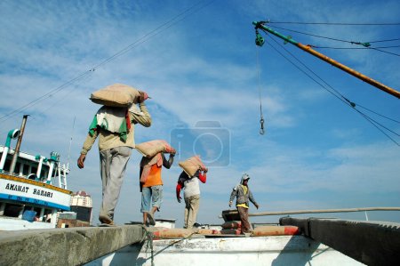 Téléchargez les photos : Jakarta (Indonésie) - 29 mai 2010 : Des travailleurs transportent du ciment des camions aux navires du port de Sunda Kelapa, Jakarta (Indonésie) - en image libre de droit