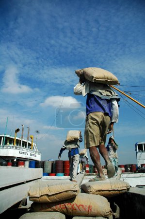 Foto de Yakarta, Indonesia - 29 de mayo de 2010: Los trabajadores transportan cemento de camiones a barcos en el puerto de Sunda Kelapa, Yakarta - Indonesia - Imagen libre de derechos