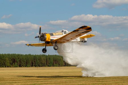 Téléchargez les photos : PZL M18 Avion de lutte contre les incendies Dromader lors du rejet d'un agent extincteur - en image libre de droit
