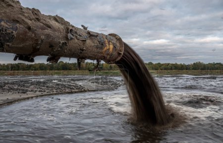 Téléchargez les photos : Tuyau de raffinage se déversant dans la rivière - en image libre de droit