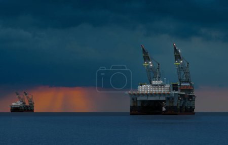 Téléchargez les photos : Plate-forme pétrolière offshore dans l'océan pendant le coucher du soleil - en image libre de droit