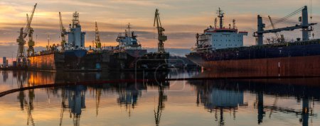 Photo for Ship repair at the ship repair yard during a spectacular sunrise-panorama - Royalty Free Image