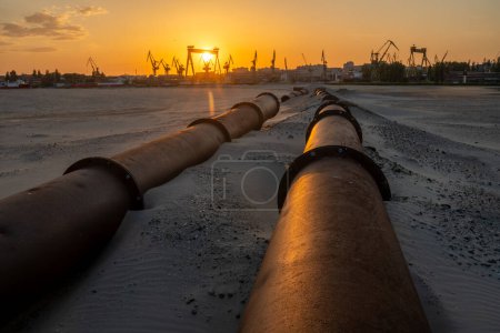 Photo for Industrial landscape:sunset over industrial areas,pipelines running through sandy desert - Royalty Free Image