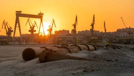 Téléchargez les photos : Paysage industriel : coucher de soleil sur les zones industrielles, pipelines traversant le désert sablonneux - en image libre de droit