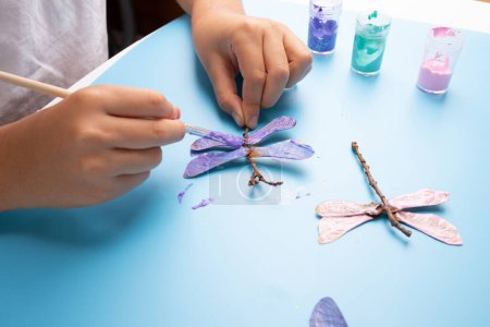 Foto de Proyecto de arte para niños libélula de materiales naturales, vista superior - Imagen libre de derechos
