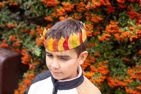 Little boy wearing a crown made of natural materials, late summer or autumn crafts, nature study for kids concept, selective focus