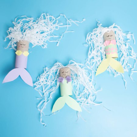 Photo for How makes a mermaid craft from paper and recycled toilet rolls, DIY . Kindergarten or school children activity, funny water nymph craft for kids, fine motor skills for preschoolers - Royalty Free Image