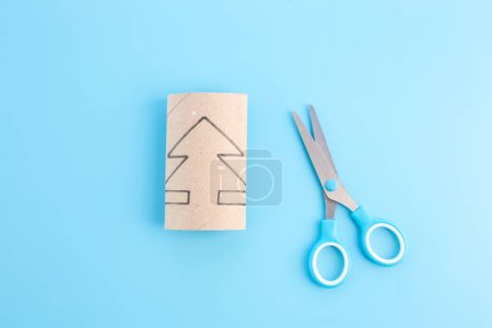 Photo for A pair of scissors sitting next to a piece of cardboard, process art, miniature spruce trees, toy package, recycled paper craft concept for kid and kindergarten, DIY, tutorial - Royalty Free Image