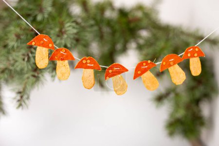 Téléchargez les photos : Guirlande de champignons en écorce de mandarine sèche, artisanat pour enfants - en image libre de droit