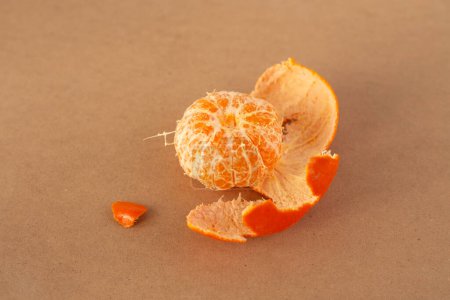 Téléchargez les photos : Une mandarine pelée assise sur une table, minimalisme, gros plan photo du produit, - en image libre de droit