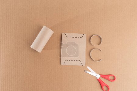 Simple idée d'artisanat du papier pour les enfants, tutoriel bricolage offre des instructions étape par étape. Étape 2 implique un modèle de carte avec des découpes carrées, placé sur un fond brun. papier projet d'art bélier, 