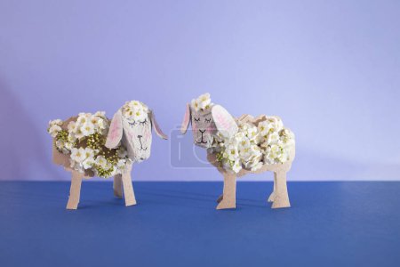 Spark your childs creativity with this fun DIY activity. Transform egg carton box and paper roll tube into adorable sheep with cheerful flowers. Embrace recycling art concept 