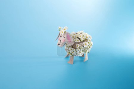 simple sheep craft from paper and recycled carton egg box, DIY . Kindergarten or school, creative craft project ideas, blue background, kids made craft, top angle view 