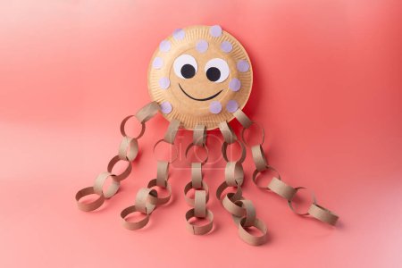 Craft project creating an octopus with simple materials, disposable plate, paper strip tentacles from empty toilet paper tubes. Engaging and fun activity for kids and crafting enthusiasts