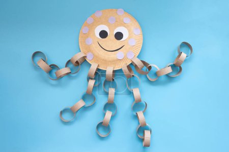 Projet d'artisanat créatif créant une pieuvre avec des matériaux simples, une plaque jetable, des tentacules de bande de papier bouclé à partir de tubes de papier toilette vides. Activité engageante pour les enfants.