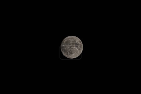 Foto de Abrazo a la luz de la luna: Telefoto Reverie en la quietud nocturna.Sumérgete en la belleza etérea de la luna casi llena, capturada con asombroso detalle en medio de la noche tranquila - Imagen libre de derechos